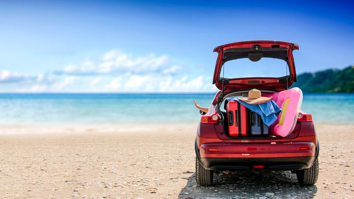 Carro com malas de viagem na praia